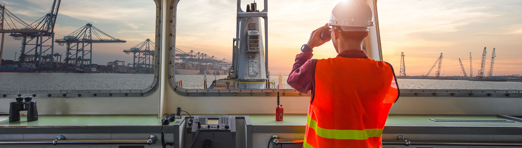 Transmarine worker with with binoculars looking out from a ship.