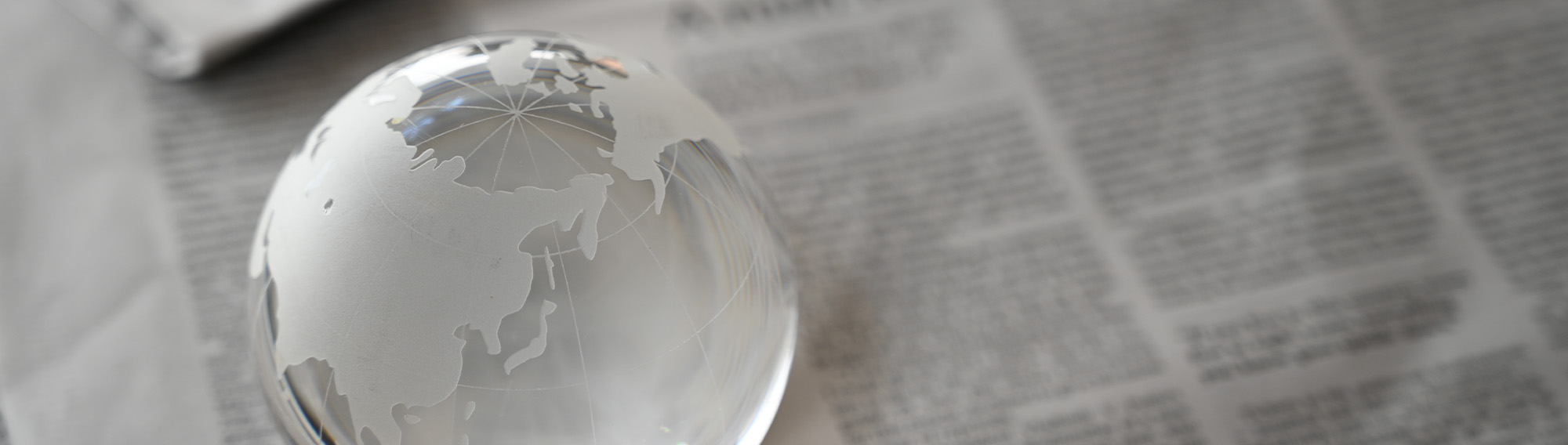 An opaque globe sitting on top of newspapers